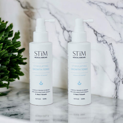 Stïm Haircare stimulating growth tonic duo bottles in a natural setting, showcasing the product for promoting hair growth.