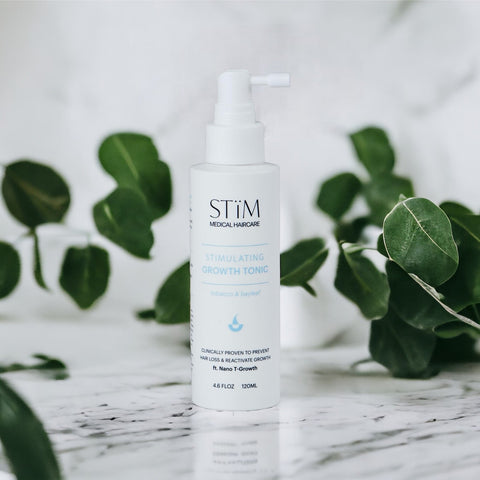Stïm Haircare stimulating growth tonic bottle with dropper, designed to promote healthy hair growth and scalp health.
