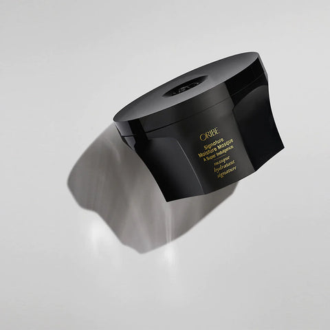Oribe Signature Moisture Masque treatment jar with white lid and black packaging, designed for nourishing hair hydration.