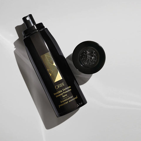 Oribe Invisible Defense Universal Protectant Spray for styling, 175ml, with a spray bottle and clear liquid inside.