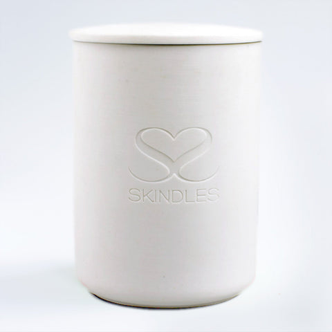 Skindles Mandarin & Mimosa candle in a decorative vessel, showcasing a stylish candle with vibrant orange and yellow hues.