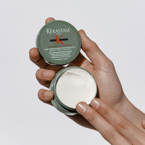 Kérastase Genesis Homme Texturisante Thickening Clay in hand, styling paste for men, 75ml, with a textured, matte finish.