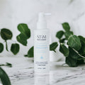 Stïm Haircare stimulating growth tonic bottle with applicator brush for promoting hair growth and scalp health.