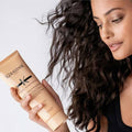 Kérastase Curl Manifesto bundle featuring a curl fondant product with curly hair and styling elements in a natural setting.